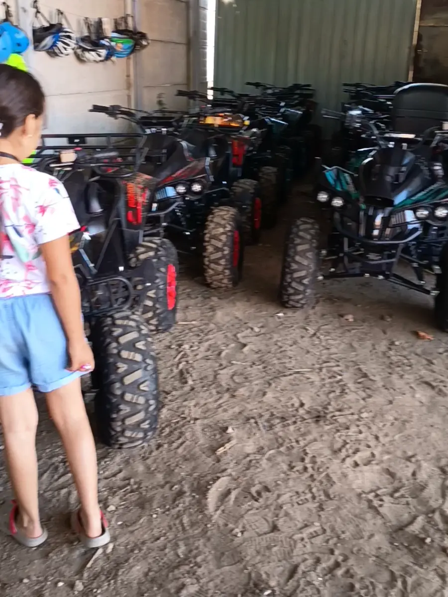 O fetiță se uită la ATV-urile noastre parcate în garaj